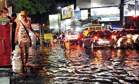 Commuters had a tough time as roads became unusable after rains pounded the City. DH Photo