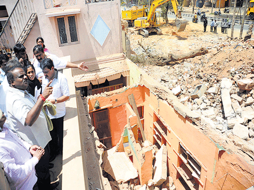 iN A SHAMBLES: Former chief minister H D Kumarswamy takes a look at the demolished buildings in Banaswadi on Tuesday. DH Photo