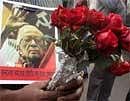 A mourner holds flowers outside the Assembly House in Kolkata to catch a glimpse of late veteran communist leader Jyoti Basu during a procession towards the anatomy department of the SSKM Hospital, to be donated to medical science as requested by Basu, in Kolkata on Tuesday. AFP