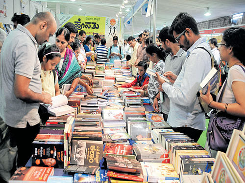 Visitors pore over books on the last day of the Bangalore Book Festival 2015, at the Palace Grounds on Sunday. DH PHOTO