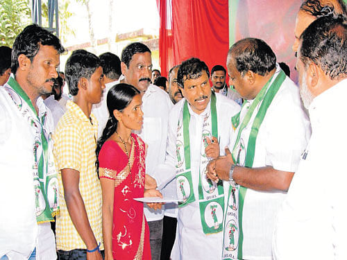 Former chief minister H D Kumaraswamy distributes financial aid to the kin of a farmer who committed suicide recently, during the JD(S) district farmers' conference at Adyanthaya Rangamandira in Mudigere on Monday. DH photo