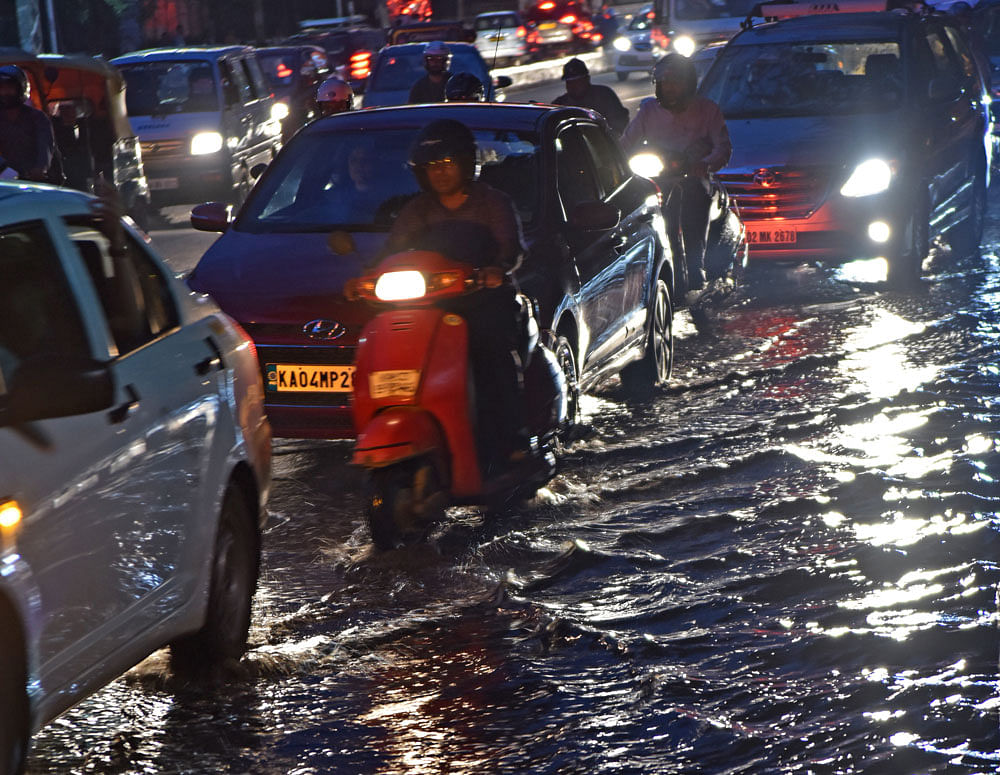 Motorists struggle to drive on the flooded Race Course Road. DH PHOTOS
