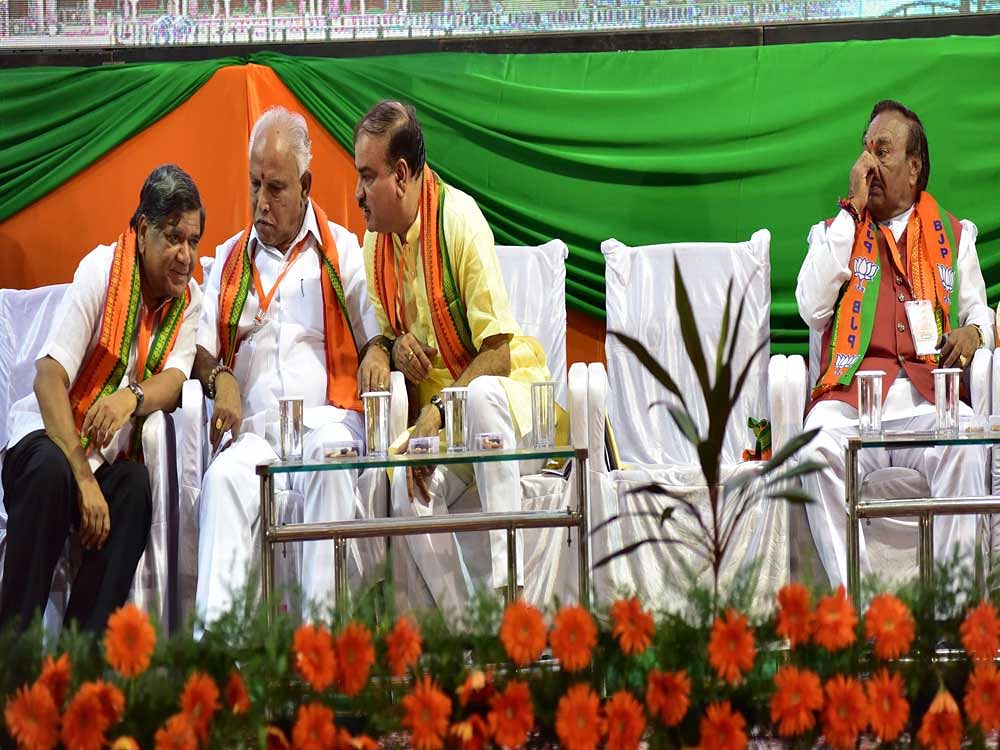 BJP leader K S Eshwarappa sits alone as Leader of the Opposition Jagadish Shettar and Union minister Ananth Kumar talk to state unit chief B S Yeddyurappa in Mysuru on Saturday. DH Photo/ Irshad Mahammad
