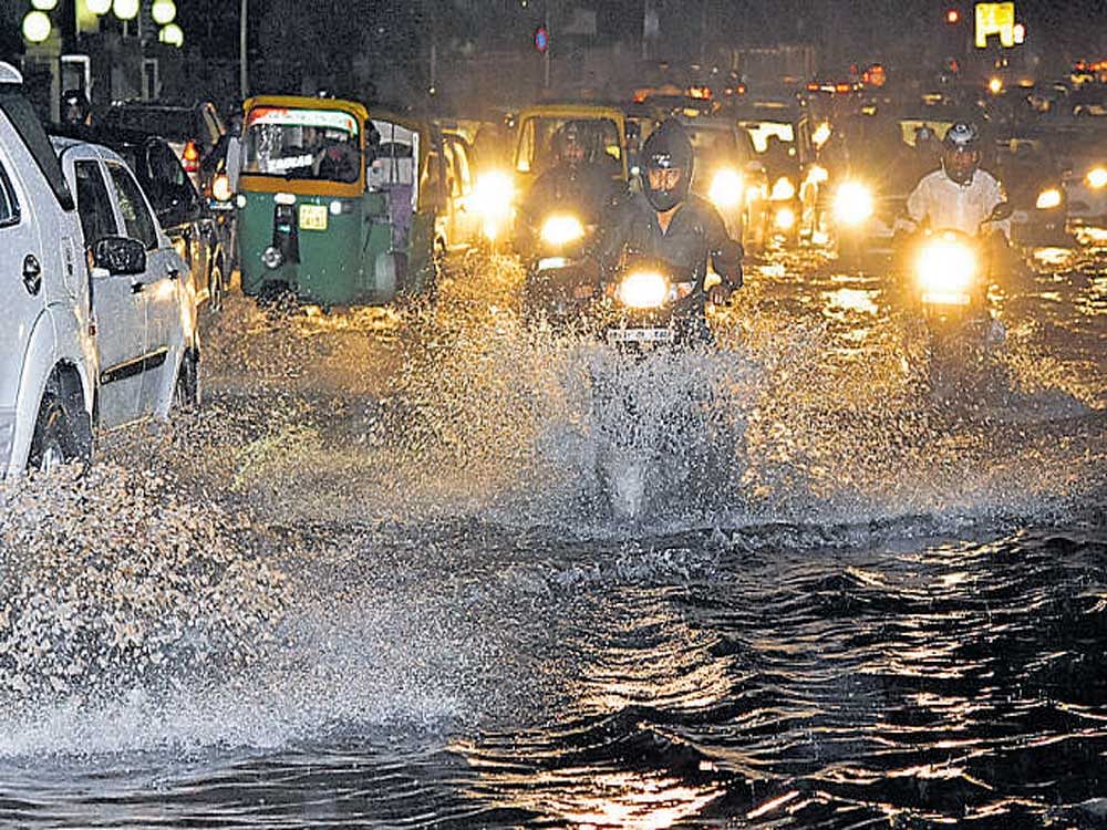 Vehicles pass through waterlogged Sankey Road in front of Le Meridien on Saturday. DH Photo/ S K Dinesh
