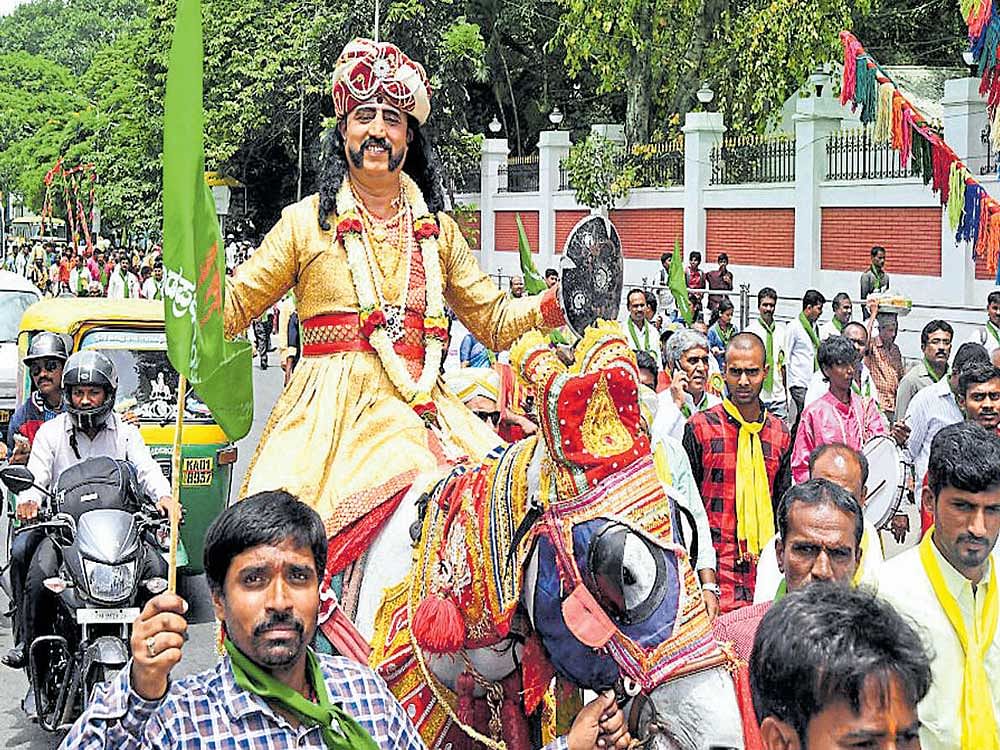 An artiste dressed as Kempegowda rides a decorated horse as part of the procession  taken out on the occasion of Kempegowda Jayanti in the city on Tuesday. DH&#8200;Photo