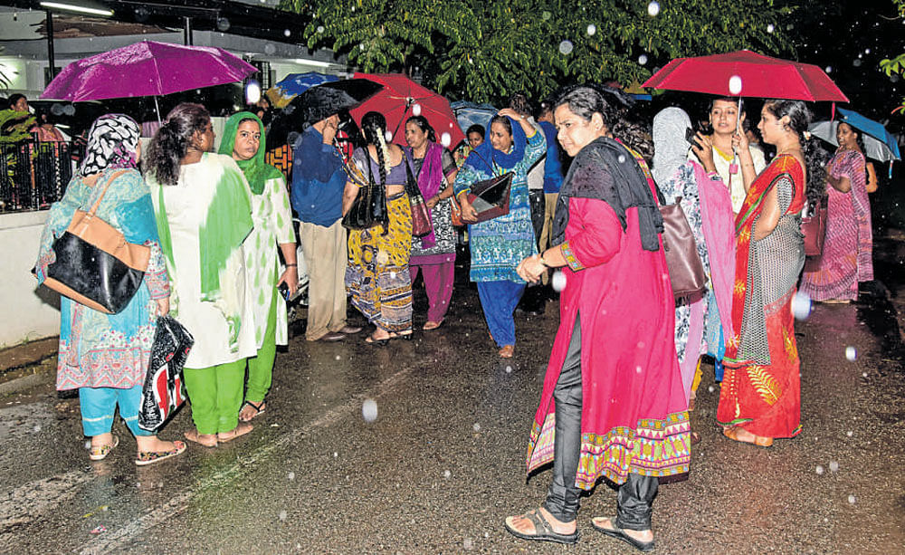 Braving rain, staff of Baldwin Girls School stage a protest in front of the institute's chairman, Bishop N L Karkare's residence in the city on Thursday. DH&#8200;Photo