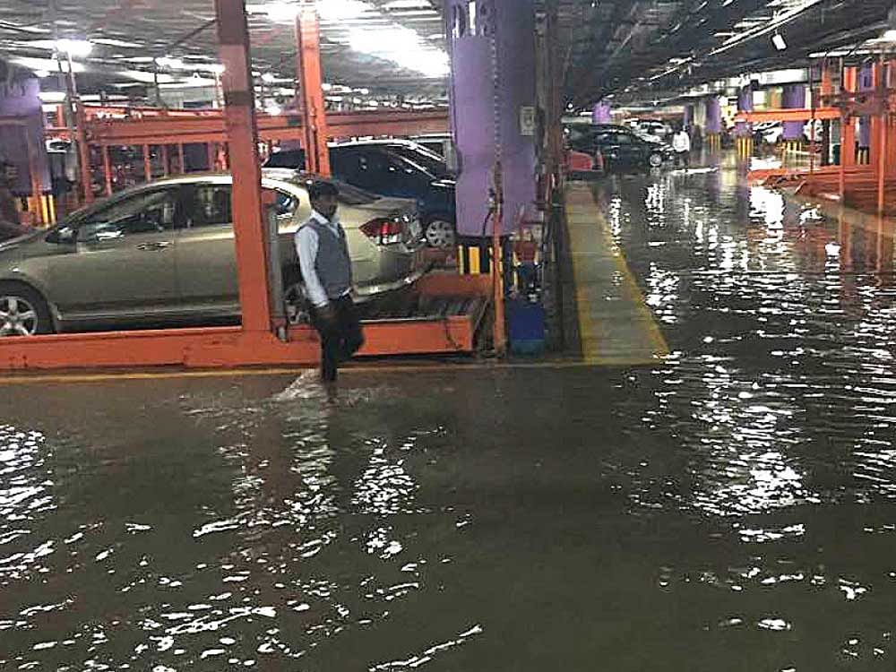 Parking place of Mantri mall on Sampige road in Malleswaram flooded due to heavy rain in Bengaluru on Friday. DH Photo.