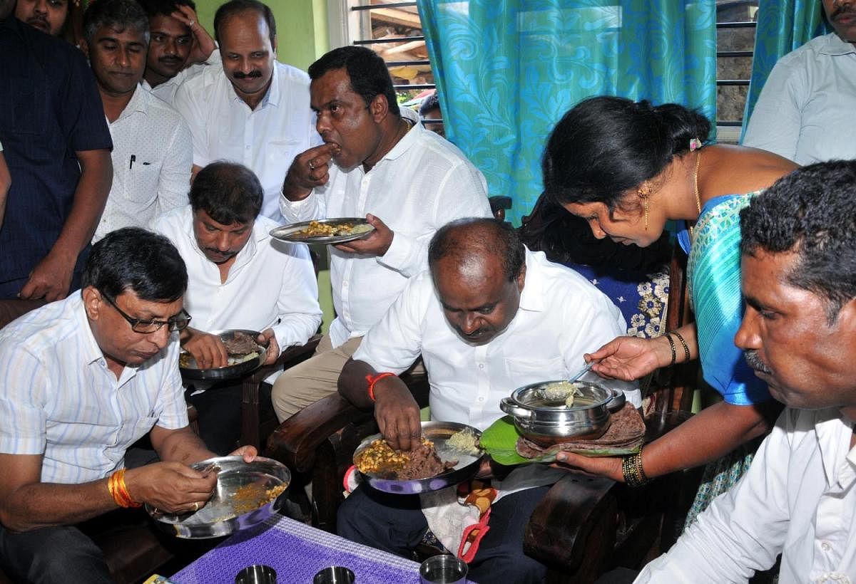 Former chief minister and JD(S) State unit president H D Kumaraswamy having refreshment in the house of Dharmapala, at Muguluvalli in Chikkamagaluru on Wednesday.