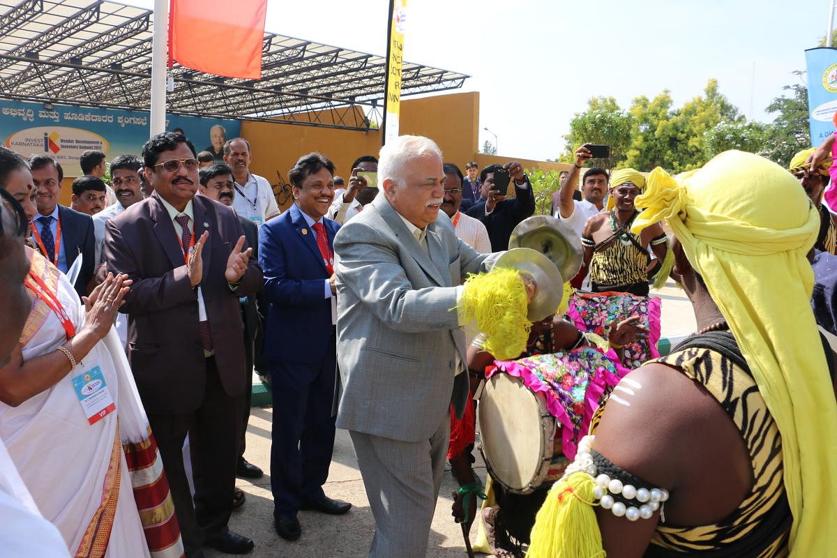 Minister for Large and Medium Scale Industries and Infrastructure Development R V Deshpande plays cymbals much to the surprise of the dignitaries and the Dollu Kunita artistes during the inaugural ceremony of Vendor Development and Investors Summit at Bangalore International Exhibition Centre on Thursday.