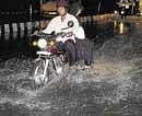 Vehicles ride through rainwater near Command Hospital, on Old Airport Road in Bangalore on Sunday. DH Photo