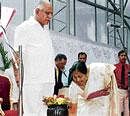 AT HIS FEET: New Minister Shobha Karandlaje touches the feet of Chief Minister B S Yeddyurappa during the swearing-in ceremony in Bangalore on Wednesday. kpn