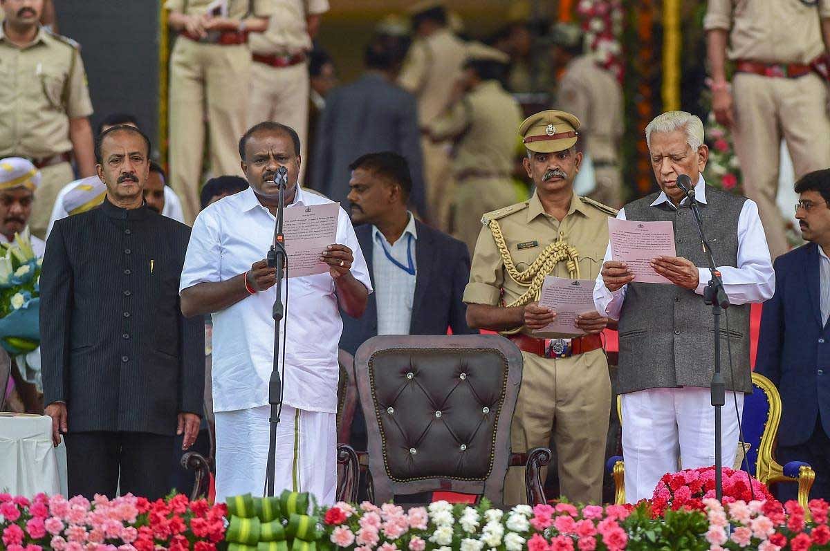 Karnataka Governor Vajubhai Vala administers the oath to JD(S) leader H D Kumaraswamy as Karnataka Chief Minister during the swearing-in ceremony, in Bengaluru, on Wednesday. PTI Photo