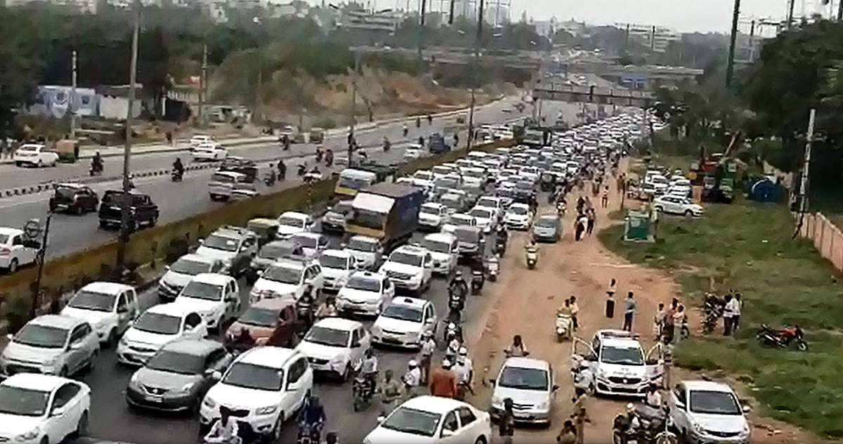 Airport-bound vehicles are stuck in the jam near the Sadahalli Gate on Ballari Road on Monday. VIDEO GRAB