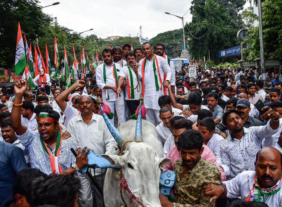 KPCC president Dinesh Gundu Rao, working president Eshwar Khandre, minister Zameer Ahmed, MLAs Narayanaswamy and N A Harris arrive in a bullock cart for a protest against hike in fuel prices, in Bengaluru on Monday.