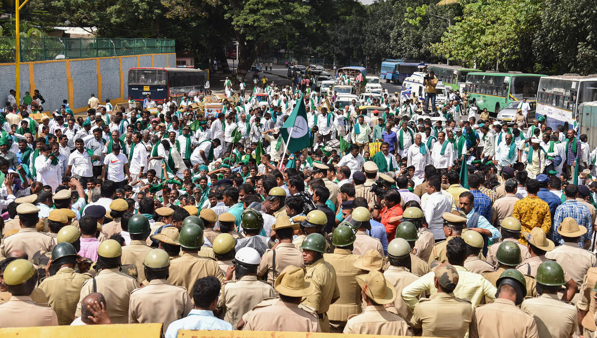 Hundreds of farmers gather in front of Freedom Park as part of their agitation in Bengaluru on Monday.