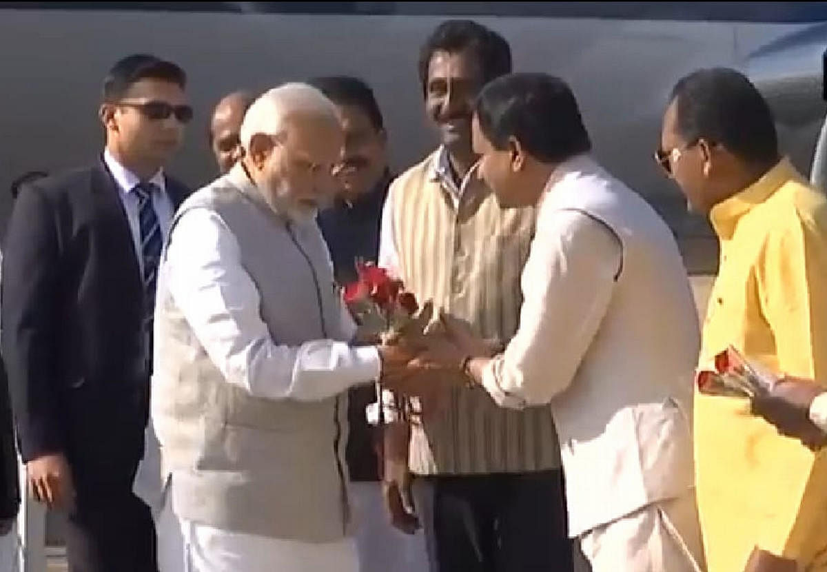 Bidar MP Bhagwant Khuba welcomes Prime Minister Narendra Modi by presenting him a bouquet at IAF airport in Bidar on Wednesday. Ministers Bandeppa Kashempur, Rajashekar Patil and Rahim Khan are seen.