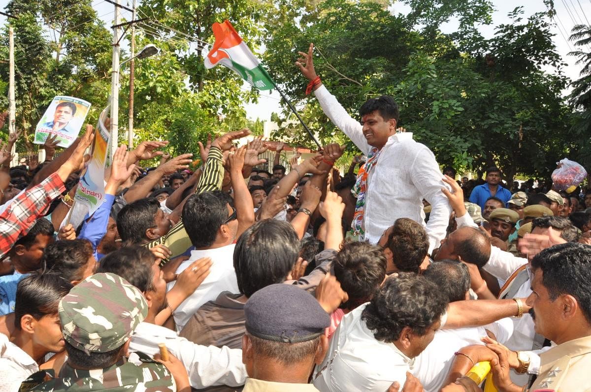 Congress candidate Ganiga P Ravikumar Gowda seen with his supporters, after filing his nomination papers in Mandya, on Tuesday. dh photo