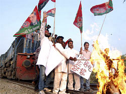 Samajwadi Party activists burn an effigy representing Prime Minister Manmohan Singh after stopping a train during a strike against a petrol price hike in Allahabad on May 31, 2012. India's opposition parties held a nationwide strike May 31, vowing to shut down the country to protest against petrol price rises announced last week. AFP PHOTO/STR