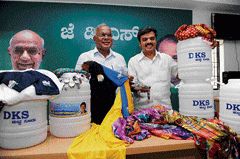 Big haul: JD(S) leaders PGR Sindhia and Vishwanath display sarees, T-shirts, wrist watches and water cans carrying picture and name of Congress MLA D K Shivakumar allegedly meant for distribution among voters, in Bangalore on Wednesday. DH&#8200;photo