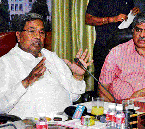 Chief Minister Siddaramaiah speaks at the Aadhaar review meeting in Bangalore on Sunday. Unique Identification Authority of India (UIDAI) Chief Nandan Nilekani is with him. dh photo