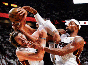 It's Mine, It's mine: Miami Heat's Mike Miller (left) and LeBron James (right) vie for a rebound with Tim Duncan (background) of San Antonio Spurs in the NBA Finals on Tuesday. Heat won the match 103-100. AFP