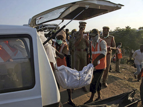 Workers load the body of a victim killed in a bus accident into an ambulance, at Mehabubnagar, Andhra Pradesh, Wednesday, Oct. 30, 2013. The bus crashed into a highway barrier and burst into flames Wednesday morning, killing more than 40 passengers who were locked inside the cabin, many of them burned alive in the inferno, officials said. AP Photo