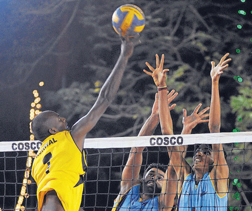 Power-packed:  BSNL's Satish Kumar (left) attempts to smash past Harminder Pal Singh (centre) and Prabhu B of JSW in their KVL match on Sunday. DH PHOTO