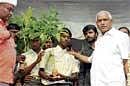 Chief Minister Yeddyurappa handing over saplings to  students as part of Greening Bangalore campaign on  Tuesday. DH Photo
