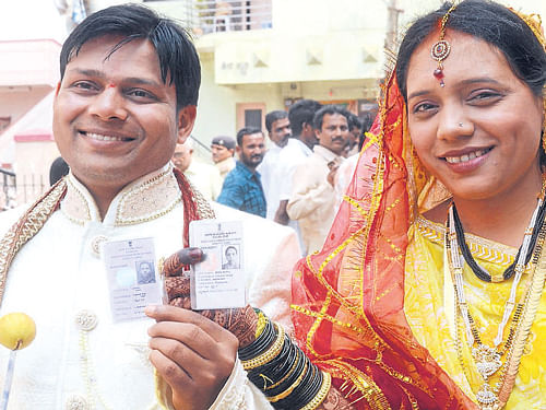 A newlywed couple come out of the polling booth after casting their votes in Hubli. DH Photo