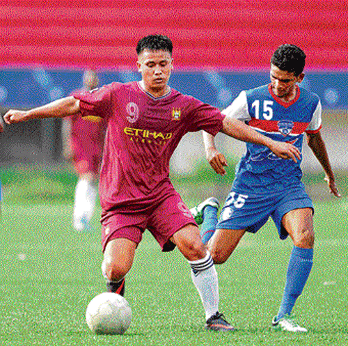 Tight contest: BFC's Rushi Anto (right) and MEG's Barjohn vie for ball on Sunday. dh photo