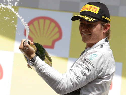 Second place Mercedes driver Nico Rosberg of Germany sprays champagne on the podium after the Belgium Formula One Grand Prix at the Spa-Francorchamps circuit, Belgium, Sunday, Aug. 24, 2014. AP Photo