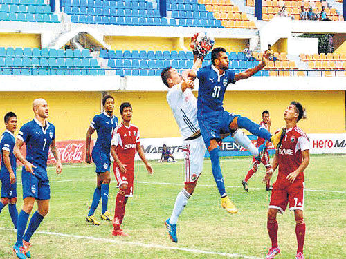 Bengaluru FC's C K Vineeth (third from right) battles to head past Shillong Lajong keeper Kungjang Bhutia during their Federation Cup encounter on Friday. BFC