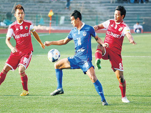 at the centre of it: BFC's Eugeneson Lyngdoh (centre) attempts to dribble past Shillong Lajong players. bfc media