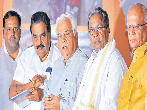 Chief Minister Siddramaiah (second from Right) unveils the logo of Invest Karnataka. Also seen are IT, BT, Science & Technology Minister S R Patil (Right) and Large and Medium Industries Minister R V Deshpande (third from Right) in Bengaluru on Wednesday. DH photo by B K Janardhan