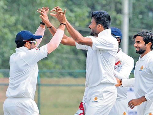 celebration time Karnataka paceman H&#8200;S Sharath (second from left) celebrates with team-mates after plucking a Delhi wicket in Hubbali on Wednesday. DH photo / M&#8200;R Manjunath