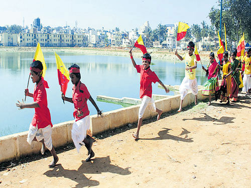 Children dressed in traditional attire carry the Kannada flag during the Byrasandra Kere Habba organised by Namma Bengaluru Foundation at the Byrasandra lake bed in the City  on Saturday. KPN