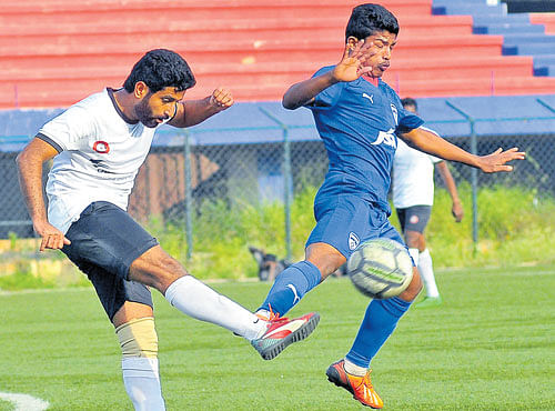 KEEN TUSSLE: Prateek Joshi (left) of Ozone FC attempts to clear the ball as Pavan of BFC closes in on him during their Super Division clash on Tuesday. DH PHOTO