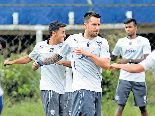 Bengaluru FC's Michael Collins (centre)warms up along with team-mates ahead of a training session on Friday. DH PHOTO/ KISHOR KUMAR BOLAR