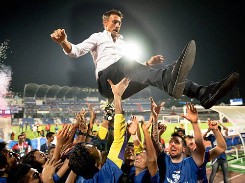 Bengaluru FC players throwing up head coach Ashley Westwood in the air as they celebrating their I-League title win after beating Salgaocar FC 2-0 in Bengaluru on Sunday. PTI Photo