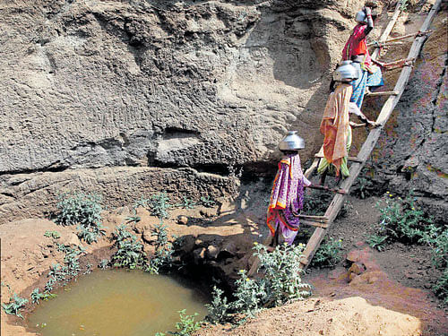 Uphill Task: Women collect water from an almost dried up well at a village in Surgana Taluka, around 95 km from Nashik, on Thursday. PTI