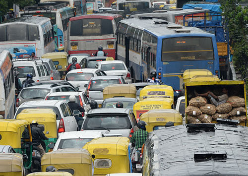 Vehicles were stranded in a huge traffic pile-up following rain on  Sheshadri Road on Wednesday. DH photos