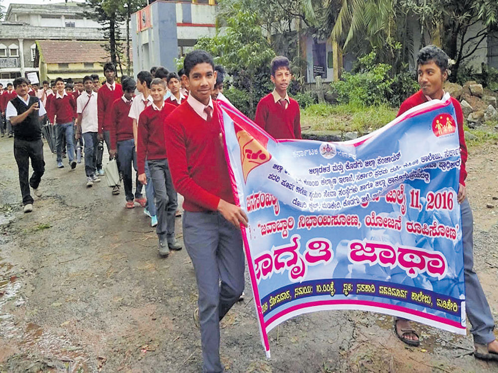 Students take out an awareness rally on the streets of Madikeri on World Population Day on Monday. DH photo