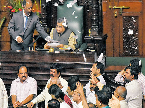 BJP members fling pieces of paper, demanding Bengaluru Development Minister K J George's resignation over DySP Ganapathi's suicide, while bills are being tabled in the Legislative Assembly on Thursday. DH PHOTO
