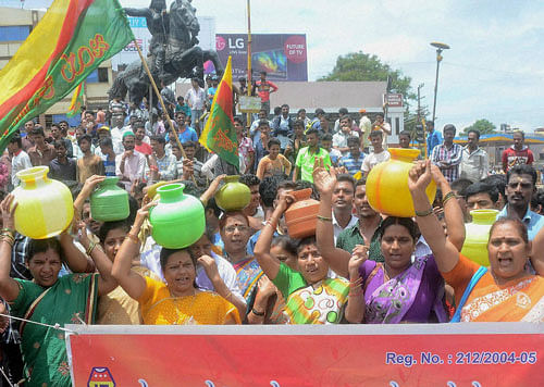 Women display empty pots as part of protests against Mahadayi river tribunal verdict in Hubli on Thursday. PTI Photo