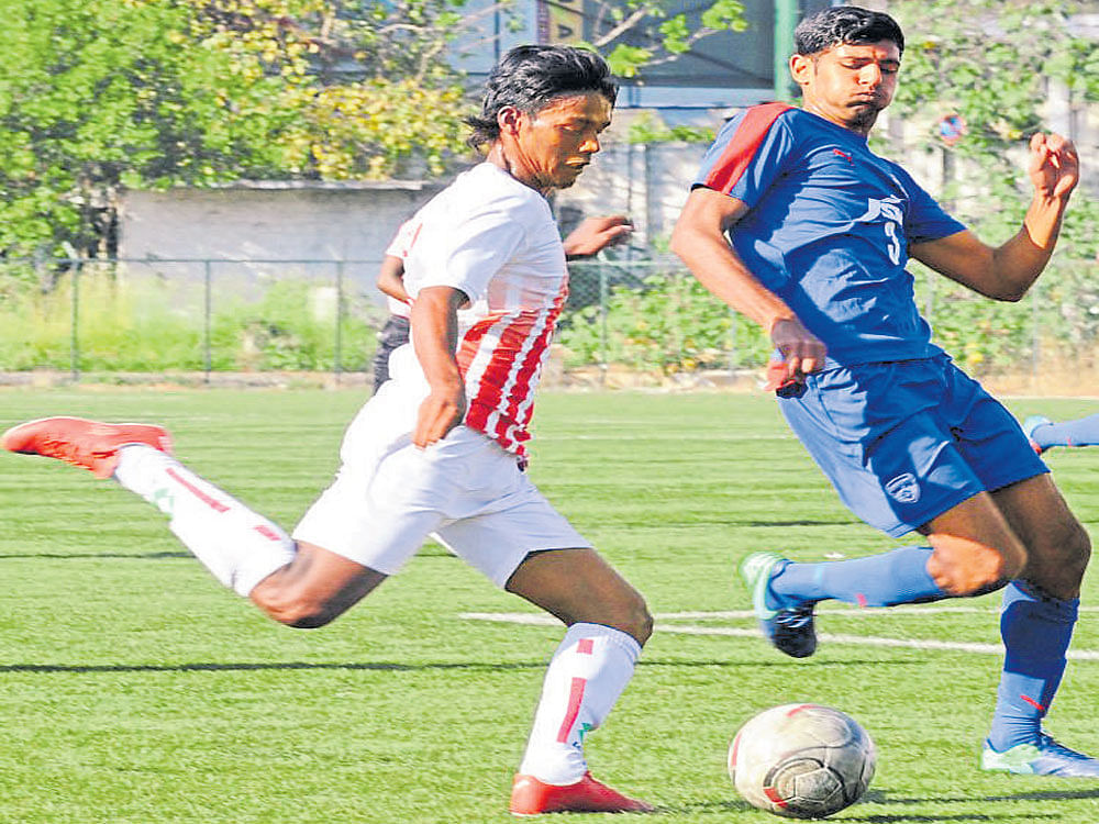 Keen TusslE: CIL's Vijay Prabhakar (left) attempts a shot as BFC's Gurshan Singh tries to put in a tackle during a Super Division match on Monday. DH photo