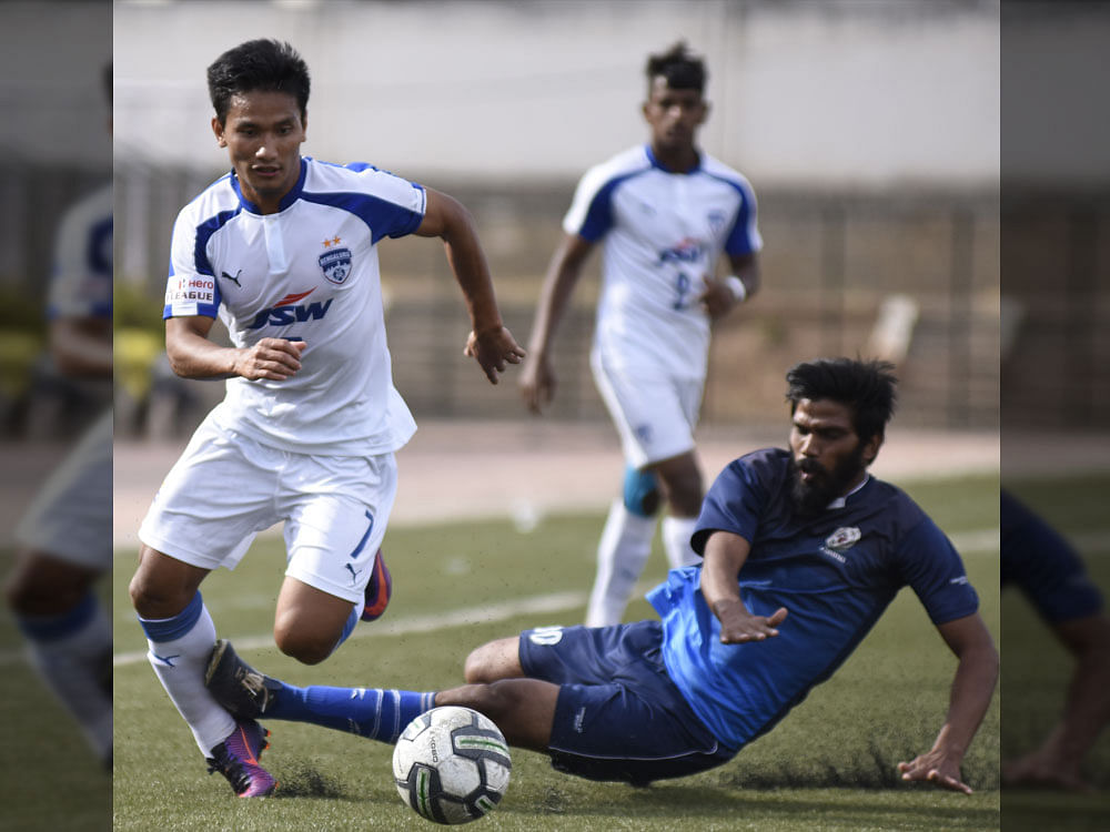 Hat-trick hero: BFC's Seiminlen Doungel (left) evades a tackle by AGORC's Pradeep on Thursday. DH photo