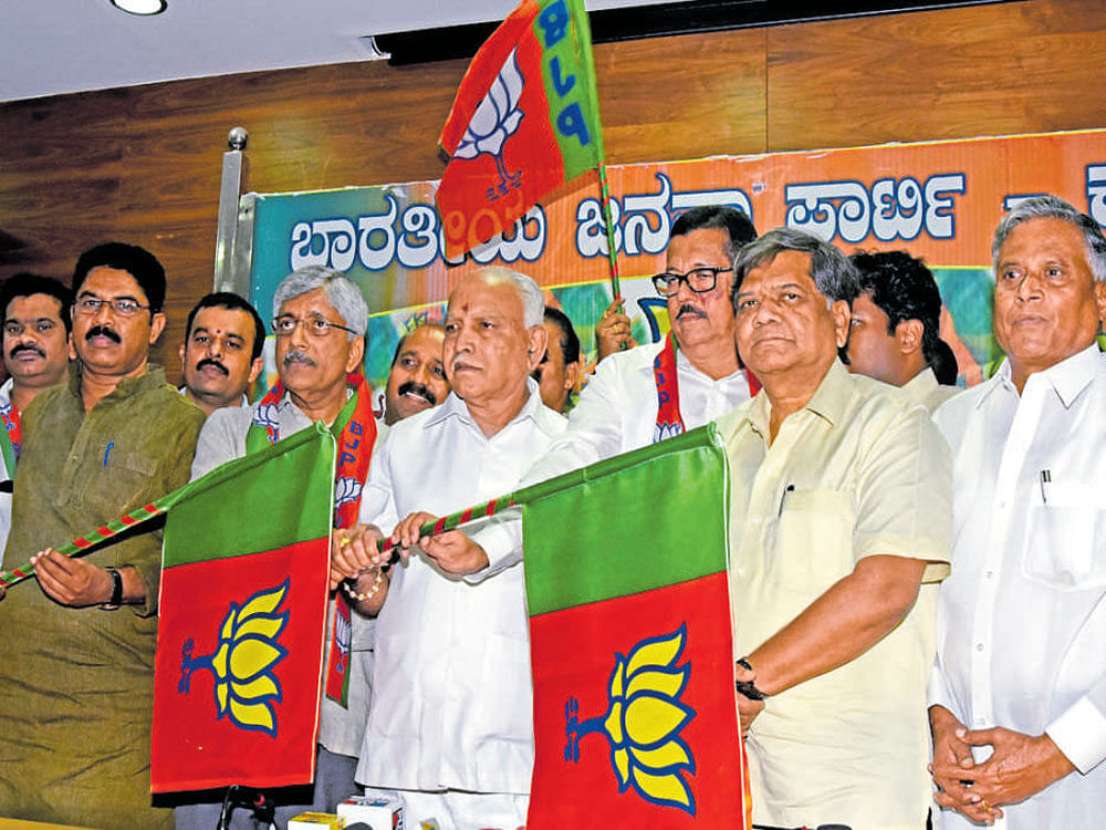 State BJP president B S Yeddyurappa hands over the party flag to former MP Jayaprakash Hegde after his induction into the party in Bengaluru on Wednesday. Former deputy chief minister R&#8200;Ashoka, former chief minister Jagadish Shettar and former minister V&#8200;Somanna and others are seen. dh photo