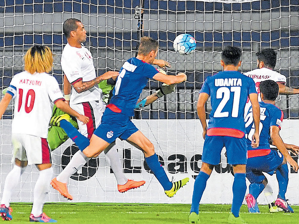 missed opportunity: BFC's John Johnson's (centre) attempt to head the ball in is thwarted by Mohun Bagan defence during their I-League match in Bengaluru on Saturday. dh photo/ kishor kumar bolar