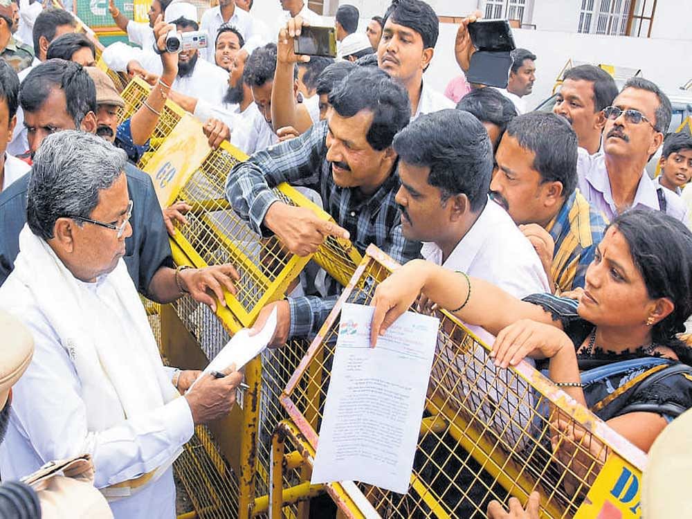 Chief Minister Siddaramaiah receives petitions from people about their grievances near his residence at T K Layout, in Mysuru, on Thursday. DH&#8200;Photo