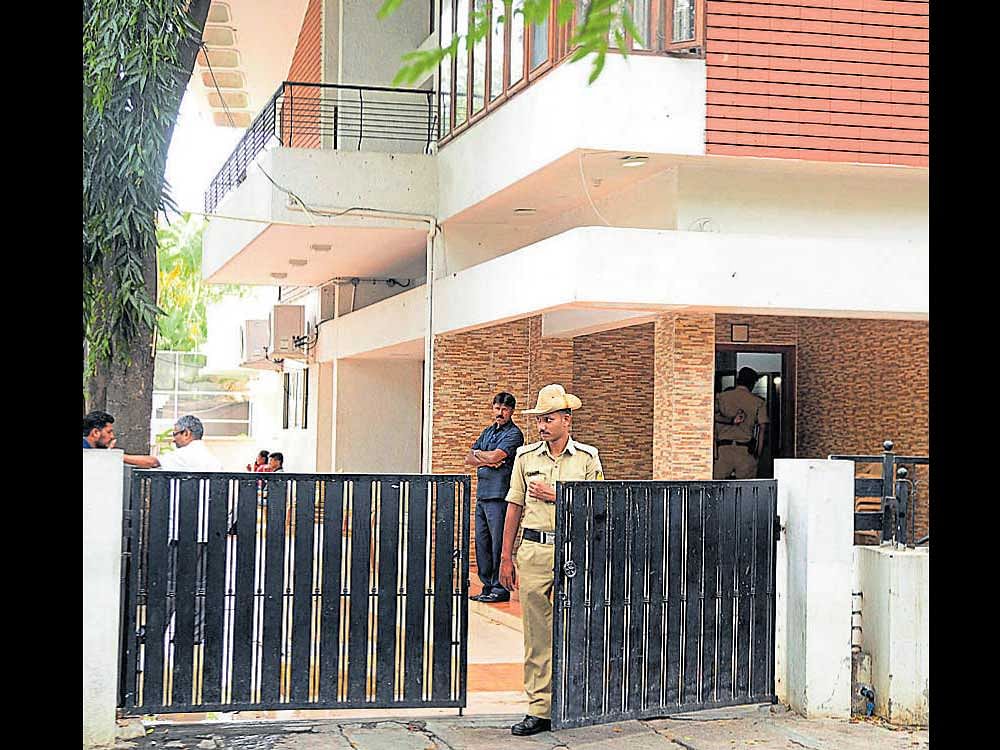 time to leave: Tight police security continued to be in place at D K Shivakumar's house in Sadashivnagar, Bengaluru  on Saturday. (Right) An Income Tax department official carries documents collected from the house of R Thimmaiah,  father-in-law of Shivakumar, at Ittigegudu in Mysuru. dh Photos